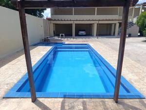 a swimming pool with a pergola next to a house at Studio Jéssica in Arunta