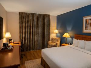 a hotel room with a bed and a chair at Baymont by Wyndham Helena in Helena