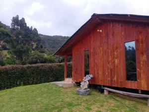 a red shed with a teddy bear in the grass at Cabaña Ortiz in Guatavita