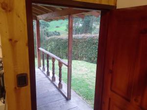 an open door to a porch with a view of a yard at Cabaña Ortiz in Guatavita +1 photo