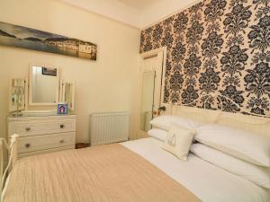 a bedroom with a bed with a dresser and a mirror at 3 Dartview in Dartmouth