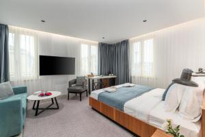 a hotel room with a bed and a tv at Arriba Rooms in Poreč
