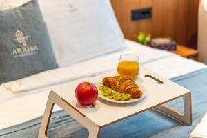 a tray of food and an apple and orange juice on a table at Arriba Rooms in Poreč