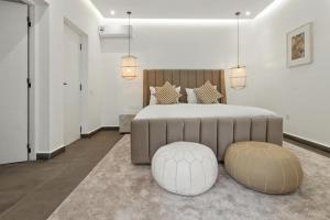 a bedroom with a large bed with two ottomans at Dariana guesthouse in Marrakesh