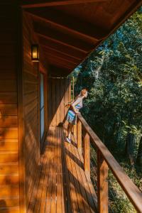 a young girl standing on the porch of a cabin at Moconá Virgin Lodge in Moconá Falls
