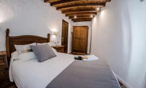 a bedroom with a large white bed and a wooden ceiling at Apartamentos Cañón de la Rinconada in Trujillo