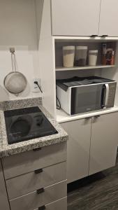 a kitchen with a stove and a microwave at Studio 4 - São Caetano proximo GM in São Caetano do Sul