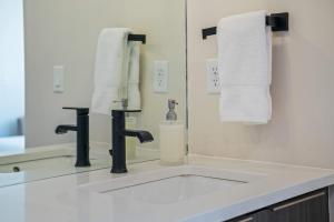 a bathroom with a sink and a mirror at Timber & Tin C 2Bed 2Bath w Pool & Rooftop Deck in Kanab
