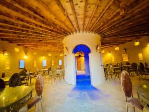 a restaurant with tables and chairs and a blue door at Adrartaziry in Siwa