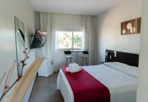 ein Hotelzimmer mit einem Bett mit einer roten Decke in der Unterkunft Hotel Oaky in Posadas