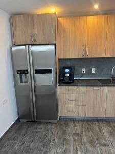 a kitchen with a stainless steel refrigerator and wooden cabinets at Timi&Amos2 in Caransebeş