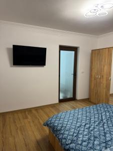 a bedroom with a bed and a flat screen tv at Timi&Amos2 in Caransebeş
