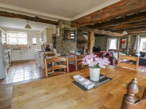 a kitchen and living room with a vase of flowers on a table at Glanyrafon Smithy in Llandysul