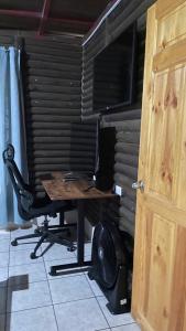 a desk with a chair next to a wooden door at Cabaña Río Sarapiquí in Sarapiquí