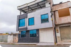 an apartment building with blue windows on a street at Departamento 1 centro de la ciudad in Santo Domingo de los Colorados