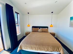 a bedroom with a bed with two pillows on it at The Modern Alpine Oasis - Mountain Views - Rainfall Shower - Perfect for Couples in Wanaka