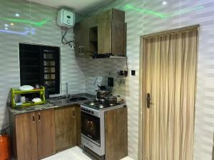 a kitchen with wooden cabinets and a stove top oven at Knock inn luxury apartment in Benin City
