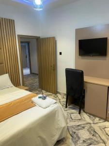 a hotel room with a bed and a desk and a chair at Knock inn luxury apartment in Benin City