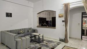 a living room with a couch and a mirror at Amenirdis Villa in Al Qurnah