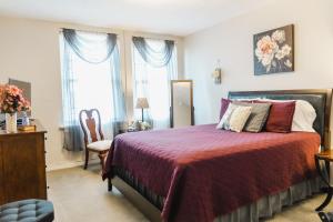 a bedroom with a bed and a chair and windows at General Denver Hotel in Wilmington