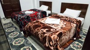 two beds sitting next to each other in a room at Amenirdis Villa in Al Qurnah