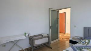 a room with a mirror and a chair and a door at Beach Home Retreat in Durrës