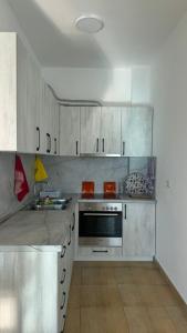 a kitchen with white cabinets and a stove top oven at Beach Home Retreat in Durrës
