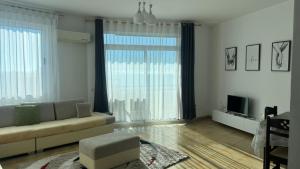 a living room with a couch and a large window at Beach Home Retreat in Durrës