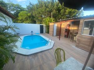 a backyard with a swimming pool on a wooden deck at Pousada - Aconchego do Sol in João Pessoa