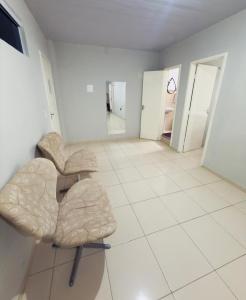 a room with two chairs sitting on a tiled floor at Flat Vila Mariana in Tianguá
