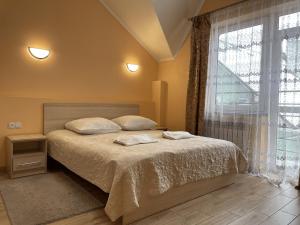 a bedroom with a bed and a large window at Золота Поляна in Polyana