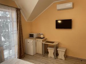 a room with a small kitchen with a microwave and a table at Золота Поляна in Polyana