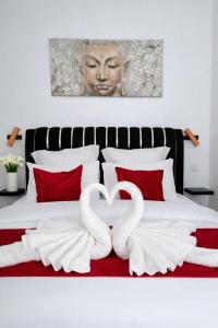 two white swans forming a heart on a bed at Le Joyau du lac in Charavines