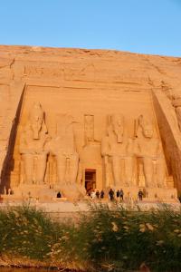 a temple in the desert with people standing in front at Sunrise in Abu Simbel