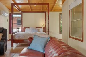 a bedroom with a bed and a couch in a room at Ironbark Villa 2 in Halls Gap