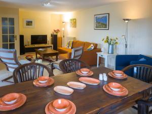 a living room with a wooden table with plates on it at Gîte Guillaume with swimming pool in Carcès