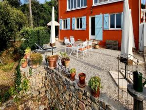 a patio with potted plants and a table with an umbrella at Gîte Guillaume with swimming pool in Carcès