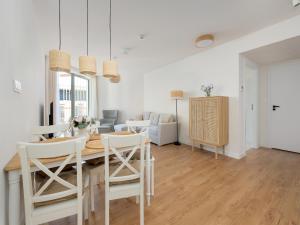 a dining room and living room with a table and chairs at Large apartment with sea view, indoor pool in Pobierowo