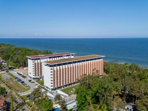 an overhead view of a building with the ocean in the background at Large apartment with sea view, indoor pool in Pobierowo