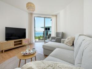 a living room with a couch and a tv at Large apartment with sea view, indoor pool in Pobierowo