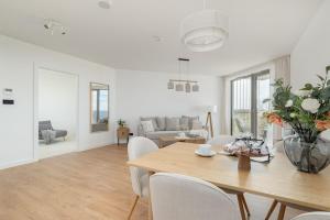a dining room and living room with a table and chairs at Apartment with direct sea view in Pobierowo