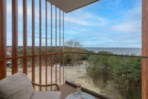 a room with a balcony with a view of the ocean at Apartment with direct sea view in Pobierowo