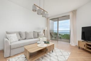 a living room with a couch and a coffee table at Apartment with direct sea view in Pobierowo