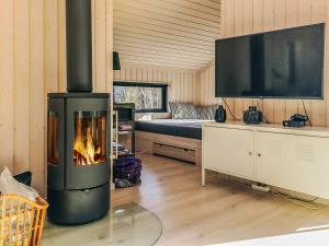 a living room with a fireplace and a tv at 8 person holiday home in Vig in Vig