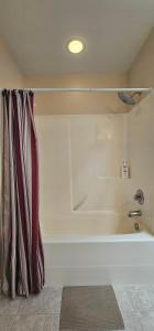 a white bath tub in a room at Eagle's House, Room #2 in Victoria