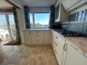 a kitchen with white cabinets and a view of the ocean at Firm Anchor in Salcombe