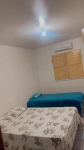 a small bedroom with two beds and a window at Hostel Teresina in Teresina