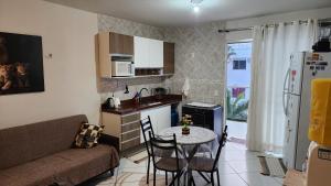 a small kitchen with a table and a couch at Apt Vista para o Mar in Conde