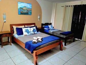 a bedroom with two beds with blue sheets at Pousada Praia do Calixto in São Francisco do Sul