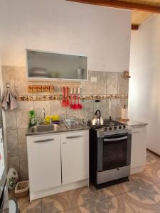 a small kitchen with a sink and a stove at Cabañas La Marca in San Pedro de Atacama